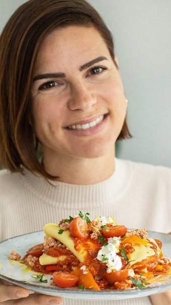 Vrouw houdt een bord lekker eten omhoog