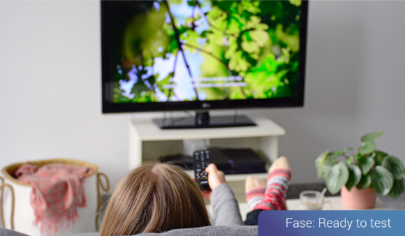 Vrouw liggend op de bank en zappend voor de TV